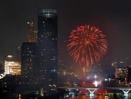 vista de ángulo alto fantástica toma multicolor de larga exposición de fuegos artificiales sobre el río chao phraya, paisaje urbano de bangkok, festival, celebración, feliz año nuevo, arquitectura empresarial. foto