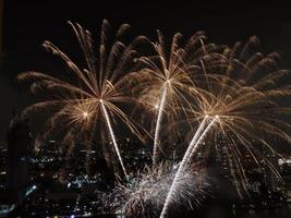 vista de ángulo alto fantástica toma multicolor de larga exposición de fuegos artificiales sobre el río chao phraya, paisaje urbano de bangkok, festival, celebración, feliz año nuevo, arquitectura empresarial. foto