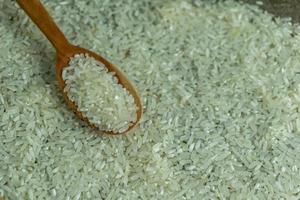 dry rice or uncooked rice. top angle view of raw rice and wooden spoon photo