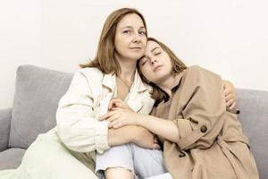 Parents and teens.Mom and teenage daughter are sitting on the couch. Conflict, difficult age. Family. photo