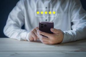 Man using a smartphone in give rating to service experience on application. Online customer review satisfaction feedback survey. photo