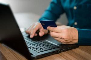 Man uses a laptop to register through a credit card to make online purchases. Credit card safe online shopping and payment concept. photo