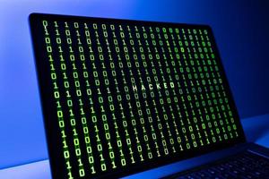 Computer Hacked concept. Laptop screen with hacked word and binary code background photo