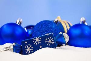 Blue Christmas balls, candy on snow with blurred background. Christmas, New Year. Copy space photo