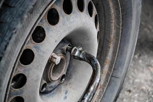 Auto mechanic changes wheel on old car. photo