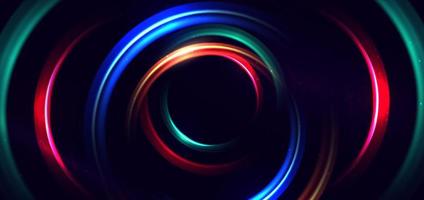 Abstract technology futuristic neon circle glowing blue, green and red light lines with speed motion blur effect on dark blue background.