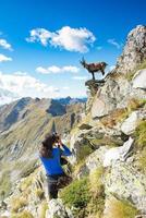 Girl hiker photographer ibex in the mountains photo