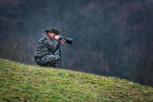 Photo hunting camouflaged in the meadow