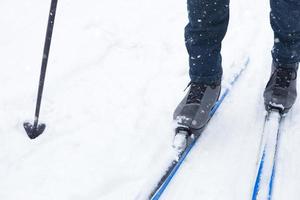 Feet of a skier in ski boots on cross-country skis. Walking in the snow, winter sports, healthy lifestyle. Close-up, copyspace photo