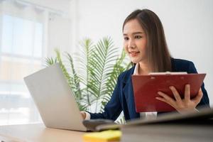 feliz joven empresaria asiática feliz y emocionada sonriendo después de recibir un correo electrónico para firmar el contacto comercial, niña feliz en el lugar de trabajo. aprendizaje a distancia educación y trabajo en línea. foto