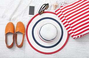 Summer accessories hat and bag on white wooden background. photo
