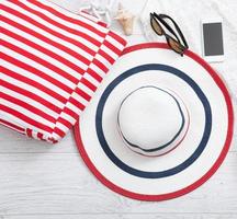 Summer accessories hat and bag on white wooden background. photo