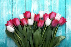marco de tulipanes sobre fondo de madera rústica turquesa. ramo de flores de primavera. fondo de primavera. fondo del día de san valentín y del día de la madre. vista superior. foto
