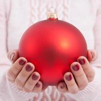 Christmas concept with hands and red, golden balls - christmas tree toy. Christmas baubles in female hands. photo