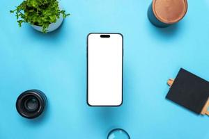 Phone mockup above a desk with objects around. Levitation above top view, flat lay composition. Isolated display for mockup, app user interface presentation photo