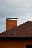 The house is equipped with high-quality roofing of shingles bitumen tiles. A good example of perfect roofing. The roof is reliably protected from adverse weather conditions photo