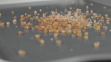primer plano de azúcar de caña marrón en un plato. grandes cristales de textura de azúcar de caña natural. video