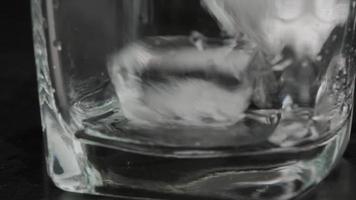 Close-up shot of ice cubes falling into empty clear glass. video