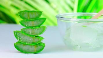 Fresh aloe vera juice in a glass bowl and sliced natural organic aloe vera with splash on nature background. medicine and beauty concept. video