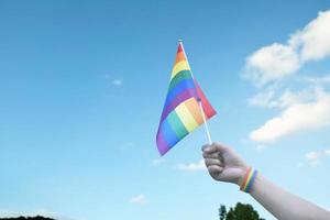 Look up view of rainbow flag, LGBT simbol, against clear bluesky background, soft and  selective focus, concept for LGBT celebration in pride month, June, around the world, copy space. photo