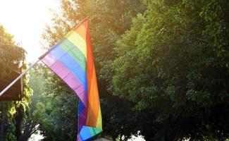 Look up view of rainbow flag, LGBT simbol, against clear bluesky background, soft and  selective focus, concept for LGBT celebration in pride month, June, around the world, copy space. photo