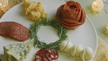 vleeswaren bord met salami, verschillend soorten van kaas. het heeft droog fruit, divers noten en honing. vakantie arrangement met brandend kaarsen