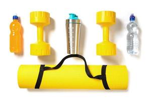 Yellow dumbbells, fitness mat and different sports drinks and nutrition photo