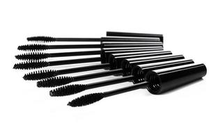 A lot of black Mascara wands on white background photo