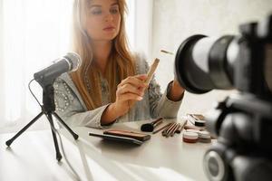 mujer bloguera de belleza haciendo una revisión en video de corrector líquido foto