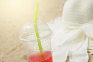 Plastic cup with a red refreshment drink and the broad brim hat photo