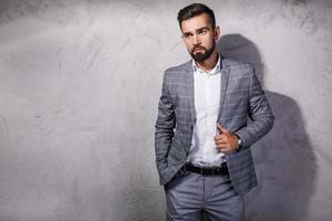 hombre guapo y barbudo con traje gris foto