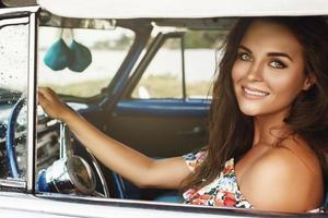 hermosa mujer conduciendo un auto convertible retro foto