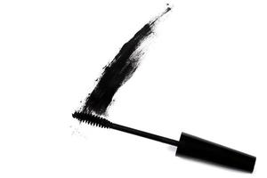 Black wand and smudged mascara on white background photo