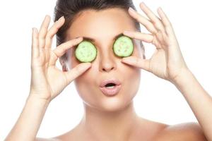 Young beautiful woman with cucumber slices photo