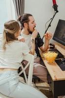 pareja comiendo bocadillos de queso mientras juega videojuegos o mira algo en línea en casa