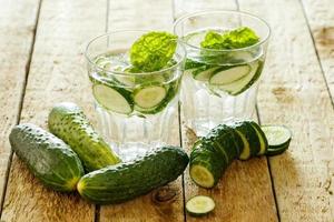 Detox water with cucumber on wooden table photo