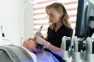 mujer durante una limpieza facial profunda en una clínica de cosmetología foto