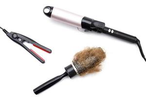 Metal round hairbrush with a clump of hair and different electronic tools for styling photo