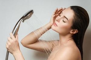 Beautiful sensual woman washing under shower spray photo