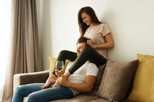 pareja feliz bebiendo vino y relajándose en casa foto