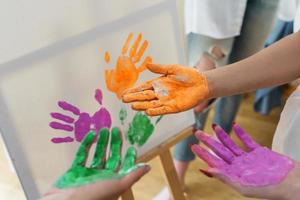 Female palms in colorful paint creating modern artwork photo