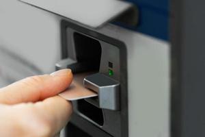 mano femenina con tarjeta de crédito y máquina expendedora de billetes foto