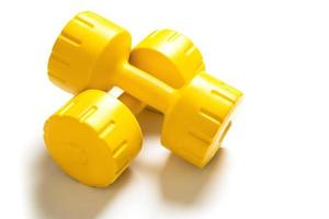 Yellow dumbbells with shadow on white background photo