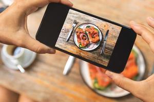 imagen en la pantalla del smartphone de deliciosas tostadas con salmón ahumado foto