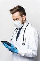 Young and confident doctor is using tablet pc photo