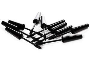 A lot of black Mascara wands on white background photo