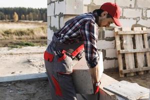 Bricklayer is working at the construction site photo