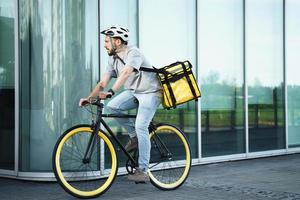 Express delivery courier riding bicycle with insulated bag. photo