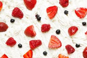 Strawberry, raspberry and blueberry in sweet whipped cream photo