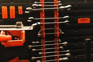 Different steel wrenches on the wall in workshop photo